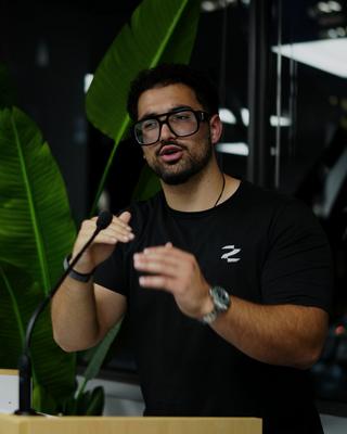 AR presenting at a podium, the Zero to Agent mark on his shirt.