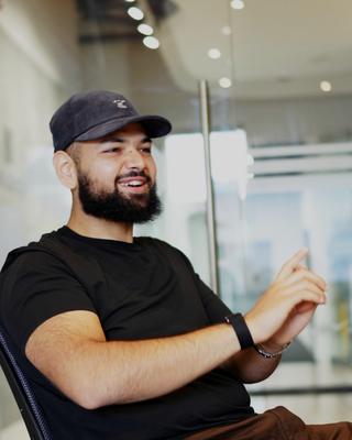 Mo smiling mid-conversation in a team meeting.