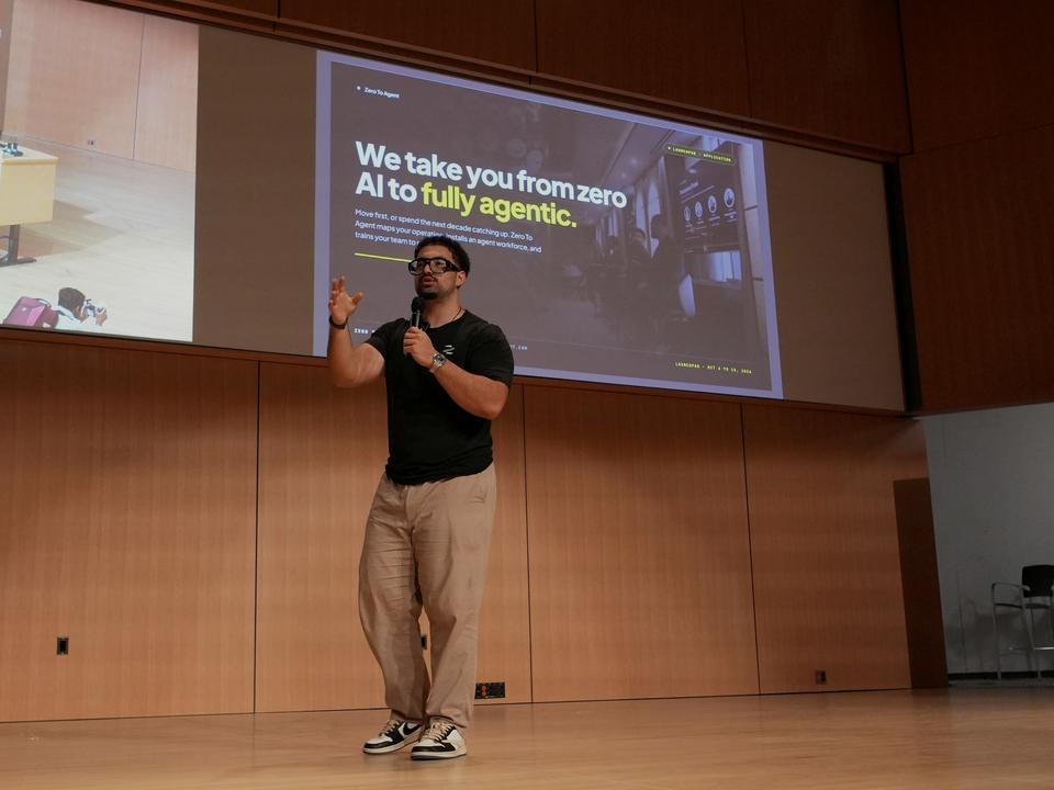 A team member presenting a Zero to Agent slide on a lecture-hall stage in Waterloo.